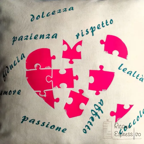 Il cuscino puzzle cuore in cotone è arricchito da un "puzzle" in vinile di emozioni di cui ogni pezzo rappresenta un frammento di amore e affetto.